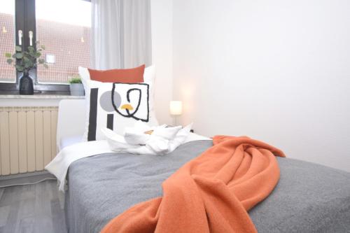 a bedroom with a bed with an orange blanket on it at GUN02-RI Apartment in Haundorf in Haundorf