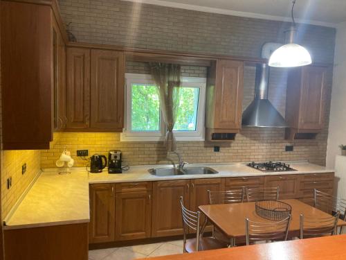 a kitchen with wooden cabinets and a table and a sink at VILLA MARIA in Kanálion