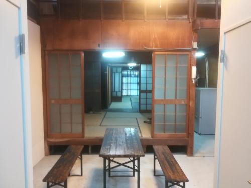 京都市にあるez guest houseのベンチとテーブルが備わる部屋