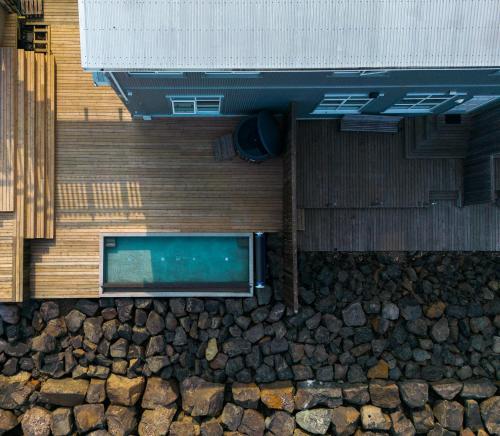 uma piscina ao lado de um edifício com pedras em Blabjorg Resort em Borgarfjordur Eystri