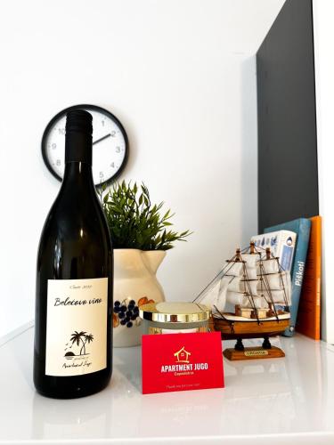 una bottiglia di vino seduta su un tavolo accanto a una bottiglia di vino di Apartma JUGO a Capodistria
