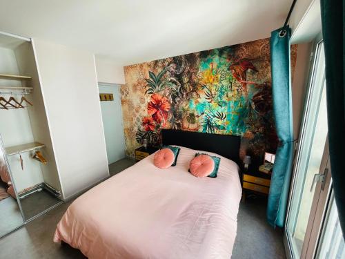 une chambre avec un lit rose avec un mur coloré dans l'établissement Au petit Théâtre, appartement Cosy en hyper centre, à Boulogne-sur-Mer