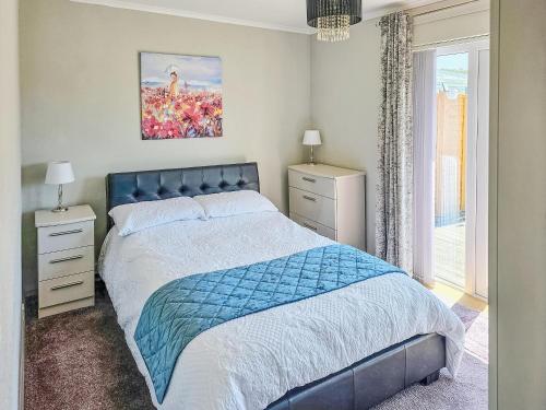 a bedroom with a blue bed and a window at Moor View in Newton Abbot