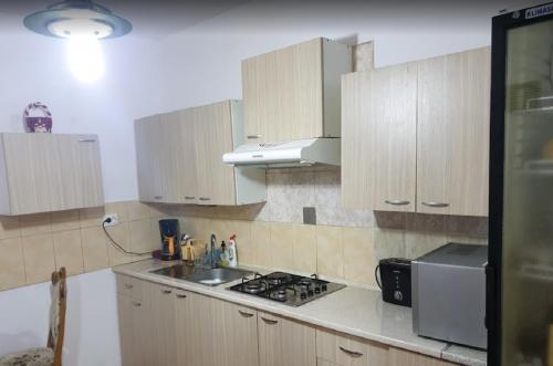 uma cozinha com armários de madeira e um forno com placa de fogão em VILA DARIA em Vartop