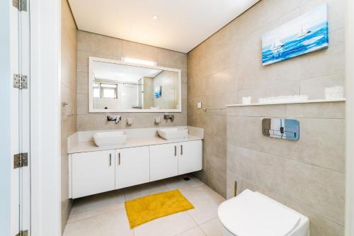 a bathroom with two sinks and a mirror and a toilet at Modern 2 bedroom apartment - Soleia 2 Apartment A9 in Pereybere