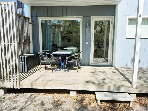 un patio con mesa y sillas en un porche en Lovely holiday apartment in Mellbystrand en Mellbystrand