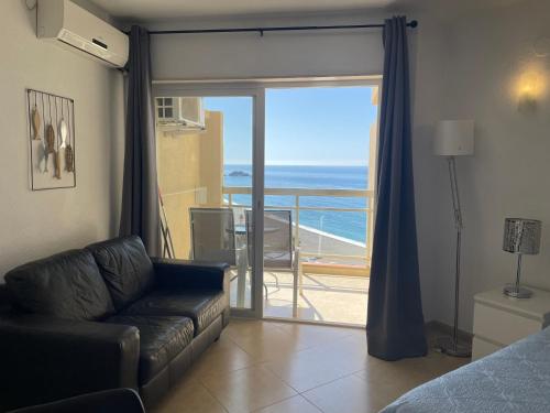 a living room with a couch and a view of the ocean at Apartamentos Apal Chinasol in Almuñécar