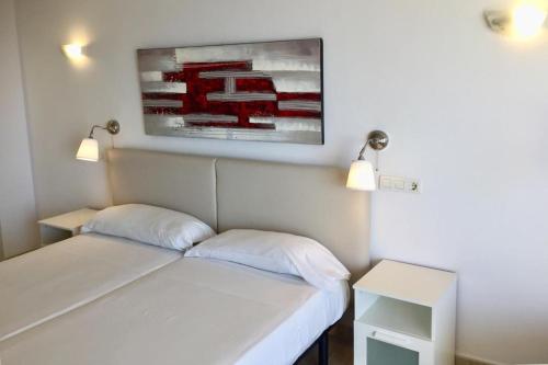 a room with two beds and a picture on the wall at Apartamentos Apal Chinasol in Almuñécar
