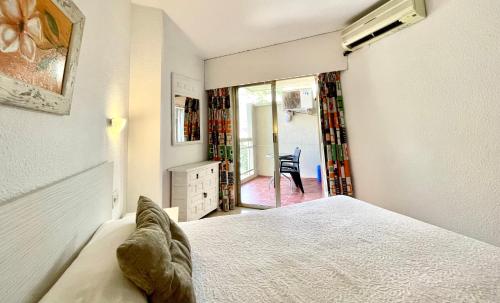 a bedroom with a bed and a room with a chair at Apartamentos Apal Chinasol in Almuñécar
