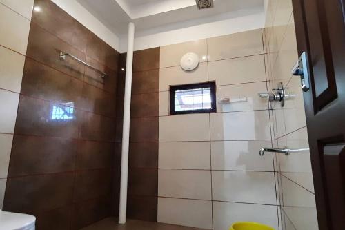 a bathroom with a shower with a glass door at Joan's Homestay Near Kumarakom in Vaikom