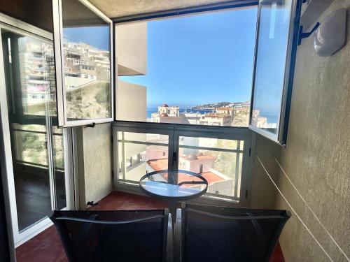 a room with two chairs and a table in front of windows at Apartamentos Apal Chinasol in Almuñécar