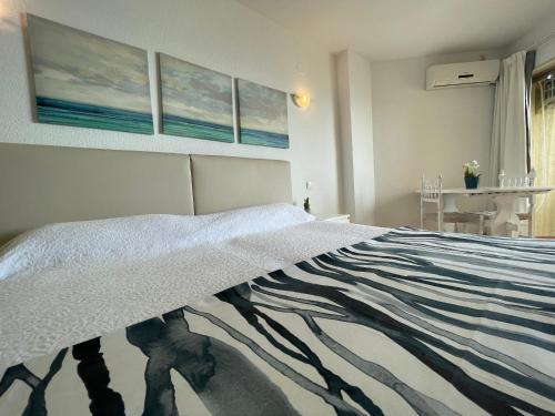 a bedroom with a bed with a blanket on it at Apartamentos Apal Chinasol in Almuñécar