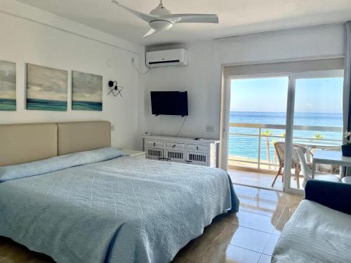 a bedroom with a bed and a view of the ocean at Apartamentos Apal Chinasol in Almuñécar