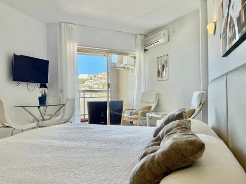 a bedroom with a bed and a room with a tv at Apartamentos Apal Chinasol in Almuñécar