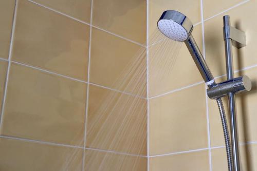 a shower with a blow dryer in a bathroom at Elegant Guest House FREE WiFi & Parking in Killingbeck