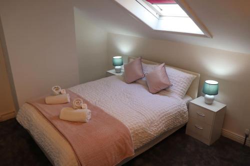 Elegant Guest House FREE WiFi & Parking في Killingbeck: غرفة نوم مع سرير مع دبتين عليه