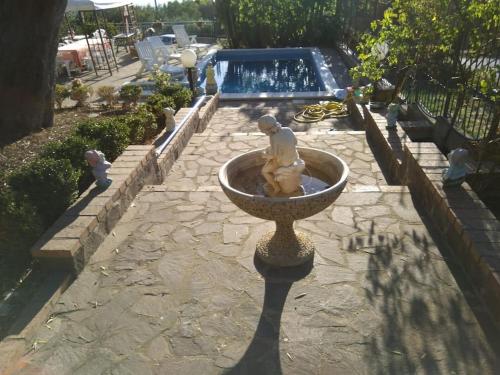 una fontana in mezzo a un cortile con piscina di villa con piscina ad Ascea ad Ascea