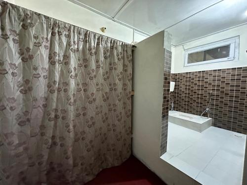 a bathroom with a shower curtain and a sink at Sultan's Guest House in Skardu