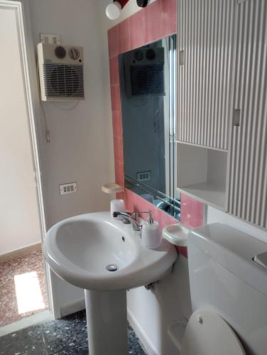 a white bathroom with a sink and a mirror at AurHouse in Castel di Iudica