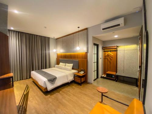 a hotel room with a bed and a table at Nata Azana Hotel Solo in Solo