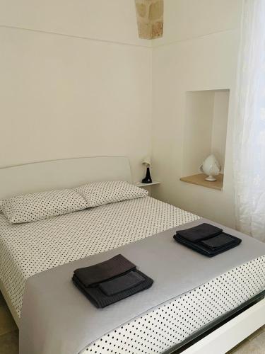 a white bedroom with a bed with two towels on it at Casa Oberdan - private parking in Monopoli