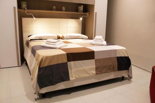 a large bed with towels on it in a room at Vico Torto Maison in Barletta