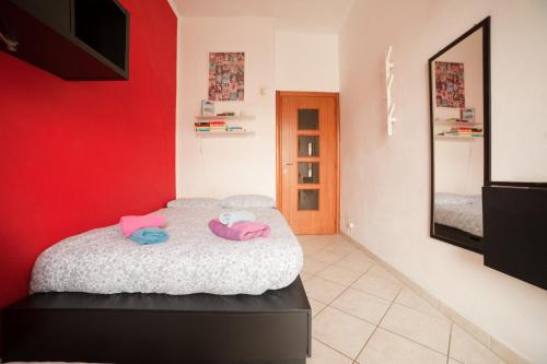 a bedroom with a bed with a red wall at Cozy ROOM STANZA close city center in a family House Stanza in appartamento condiviso noi viviamo in casa STANZA in affitto in Turin