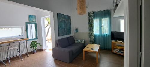 a living room with a couch and a tv at Cosy loft in Platamonas
