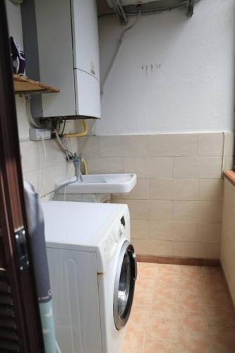 a small bathroom with a washing machine and a sink at Due minuti dal mare con Balcone Vista Mare in Tropea