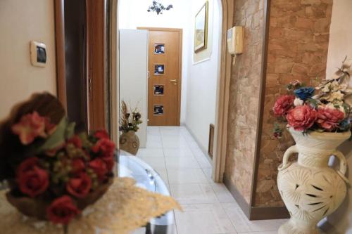 a vase with flowers on a table in a hallway at Due minuti dal mare con Balcone Vista Mare in Tropea