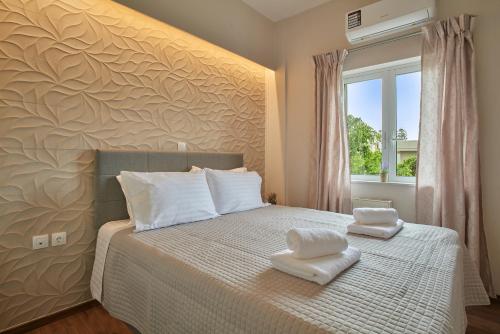 a bedroom with a bed with two towels on it at Luxurious house near the sea in Kato Daratso