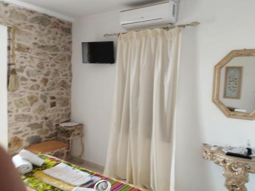 um quarto com uma cortina branca e uma televisão em Villa Elli em Amoliani