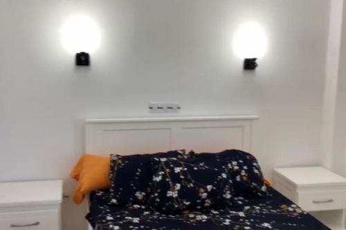 1 dormitorio con 2 luces en la pared y 1 cama en appartement plage petit paradis 