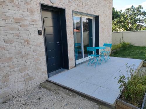 a patio with a blue table and chairs next to a building at Super studio rez de jardin avec extérieur in Lozanne