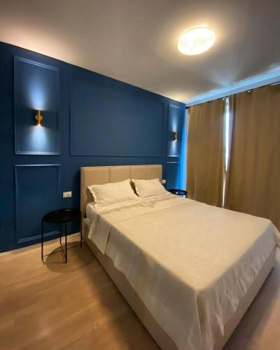 - une chambre avec un grand lit aux murs bleus dans l'établissement Sara blue apartment, à Tirana