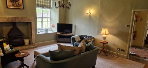 a living room with two couches and a fireplace at Braithwaite Hall Apartment in East Witton