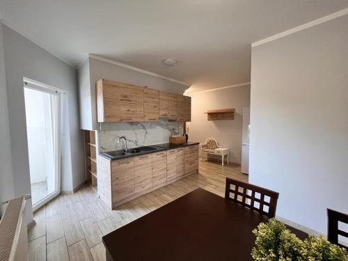 - une cuisine avec un évier et une table dans une chambre dans l'établissement Apartamenty Firfas 9, à Bydgoszcz