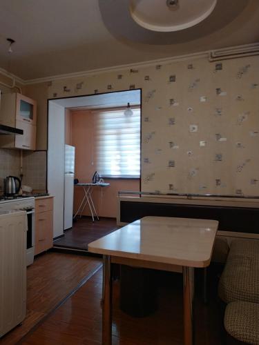 a kitchen with a table in the middle of a room at Apartment in Tashkent