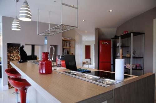 a kitchen with a counter with red stools in it at Modern 4 Bedroom House Ring of Kerry -Killarney in Killarney