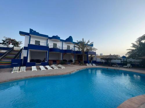 a large swimming pool in front of a house at Bedouins Inn Village in Aqaba