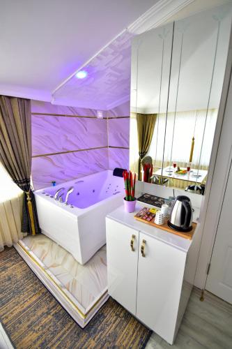a bathroom with a purple tub in a room at LOCA Suit LİFE AİRPORT HOTEL in Istanbul