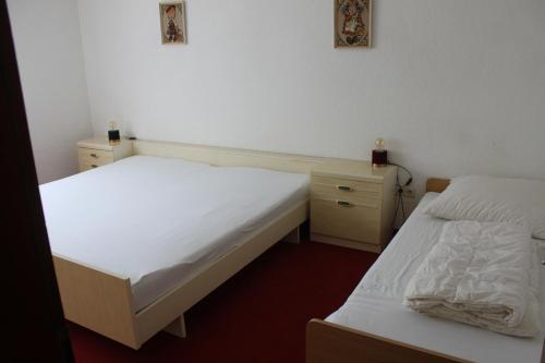 two beds in a room with white sheets at Ferienwohnung Butz in Lottstetten