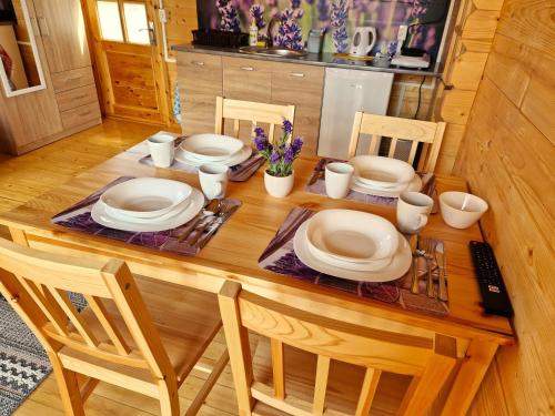 stół jadalny z białymi talerzami i krzesłami w obiekcie Pod Lawendą & Jacuzzi & Blisko Augustów w mieście Augustów