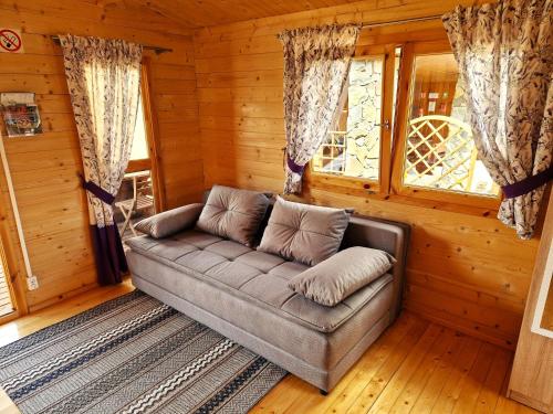 a living room with a couch in a cabin at Pod Lawendą & Jacuzzi & Blisko Augustów in Augustów