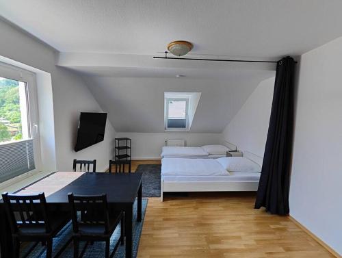 een kamer met 2 bedden en een tafel en stoelen bij SANO Apartments - DGL - Hagen Zentral - vollausgestattete Küche - Internet - Platz für bis zu 5 Personen in Hagen