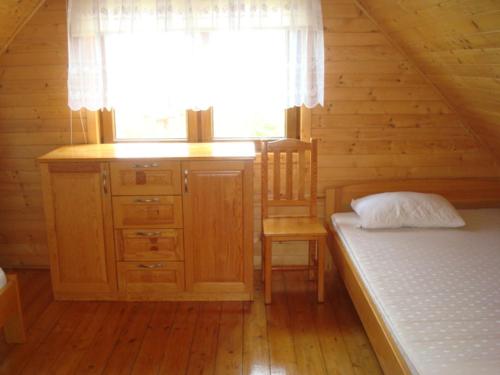a bedroom with a bed and a window in a cabin at Domki Małgorzata in Władysławowo
