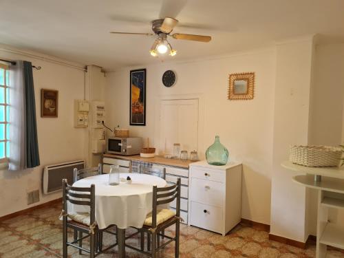 une cuisine avec une table et des chaises dans une pièce dans l'établissement Appt 2 pièces à 15 mn du Salagou, à Paulhan