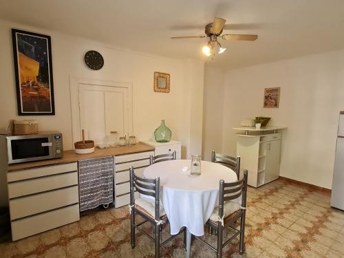 uma cozinha com mesa e cadeiras num quarto em Appt 2 pièces à 15 mn du Salagou em Paulhan