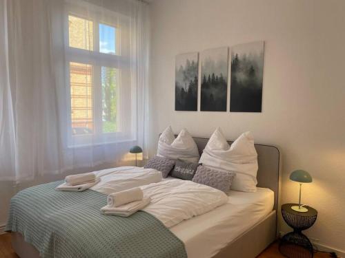 Una cama blanca con dos toallas encima. en LUCKY STAYS LS03 - 2 Zimmer - Luxus - Zentrum - große Küche - Aufzug - Smart-TV, en Magdeburgo