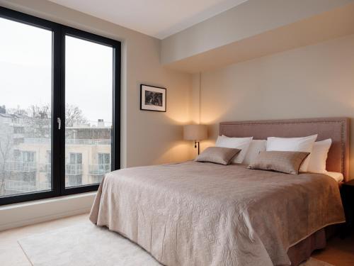 オスロにあるFully serviced luxury apartment at Sommerroのベッドルーム1室(大きなベッド1台、大きな窓付)